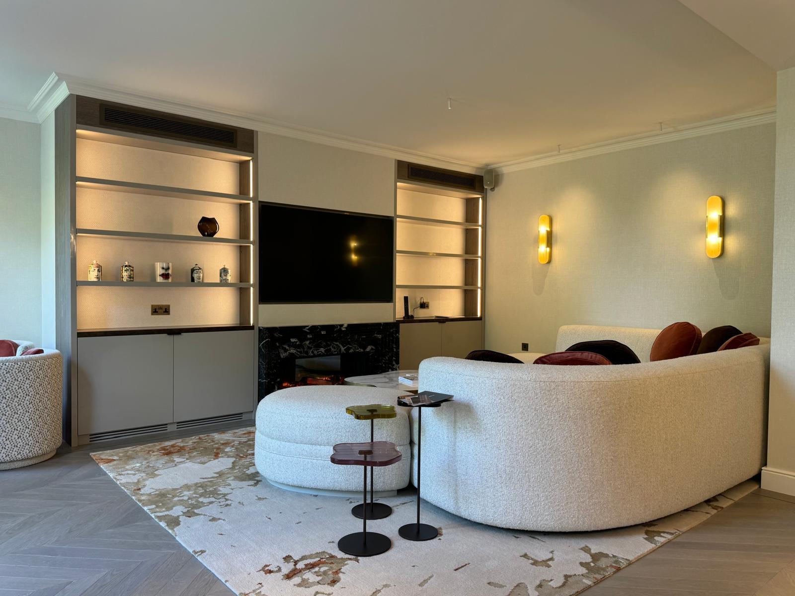 Bespoke living room cabinetry with illuminated shelves and a media wall